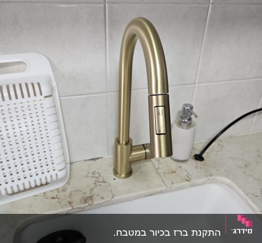 ברז זהב מותקן בכיור מטבח עם מתקן סבון